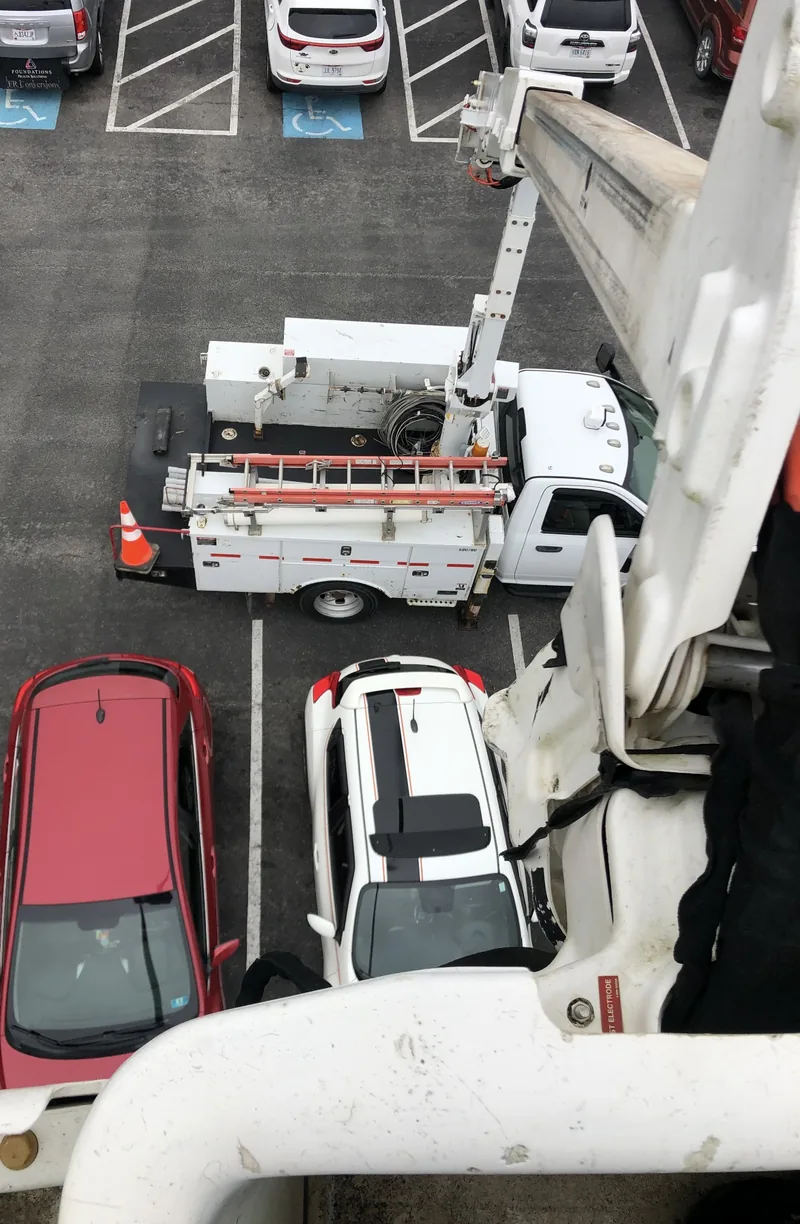 Looking down from the bucket at the DC Electric truck in a parking lot