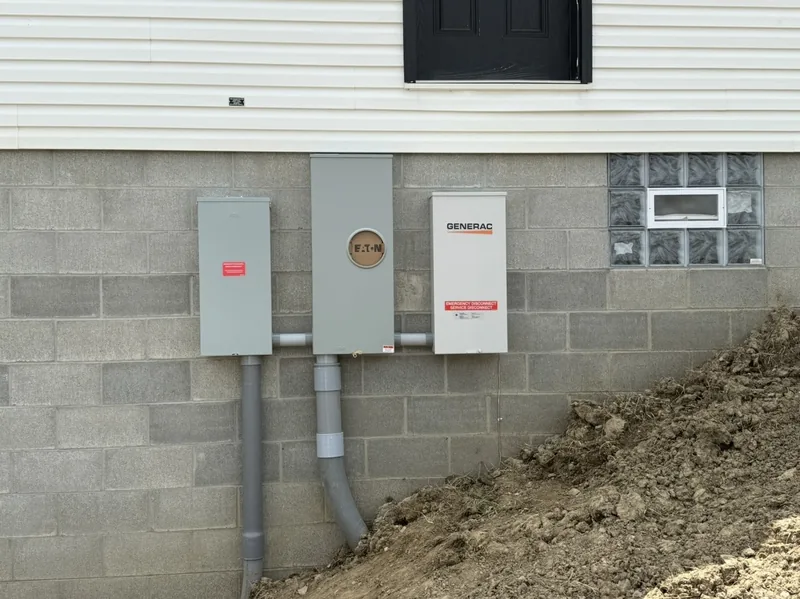 Meter, disconnect and a Generac transfer switch on a block wall