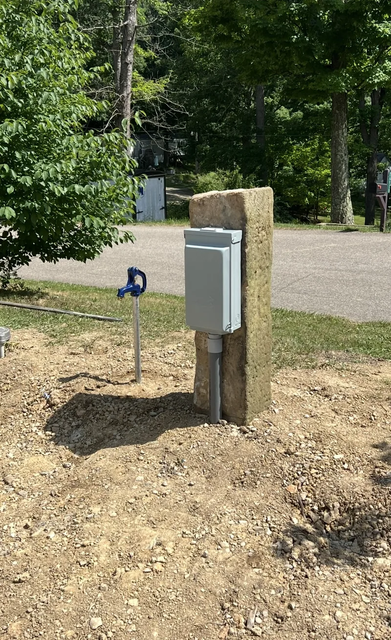 A service post with a meter set in a yard, ready for the feed