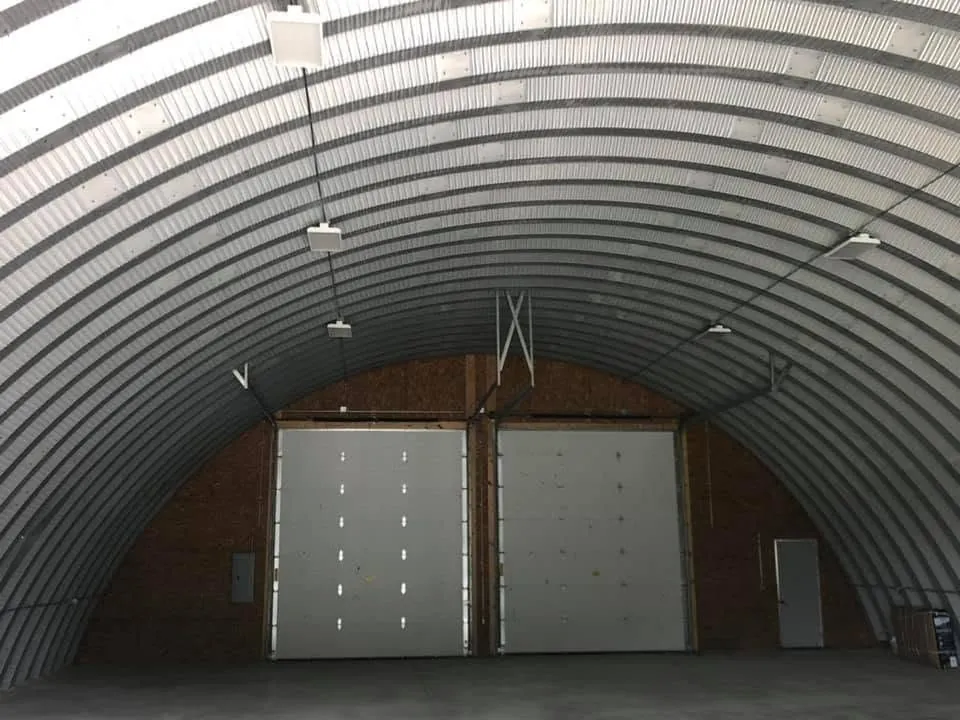 Steel arch building interior with overhead doors and new lighting, wired by DC Electric